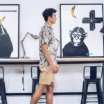 Traveler walking past Blu Monkey artwork in a creative hotel space